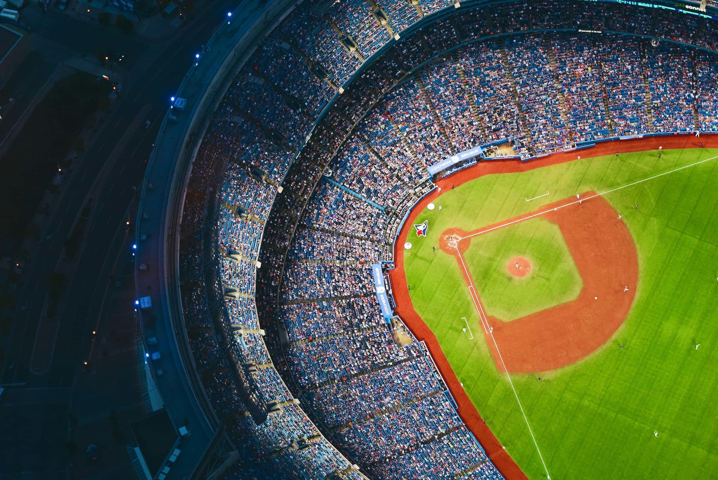 Baseball stadium at night from above, field glowing